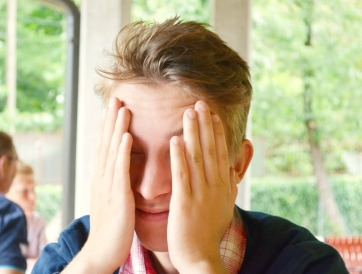 Jugendlicher stützt den Kopf in die Hände — ein Ausdruck von Prüfungsangst und Überforderung